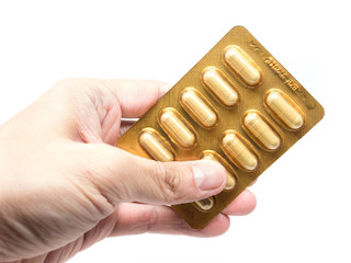 green herb capsules pills in gold blister pack