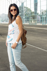 lifestyle portrait young woman walking on the street with backpa
