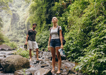 Couple on forest hike walking by a creek