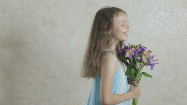 Beautiful girl with bouquet of flowers laughing.