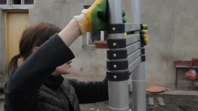Woman lays ladder in the yard