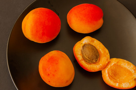 Fresh apricots in dark plate close-up