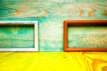 Old abstract picture frames on colored wooden background