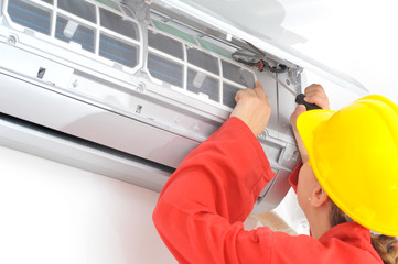 Woman electrician adjusting air conditioner system