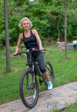 Fit healthy middle aged woman riding a bike