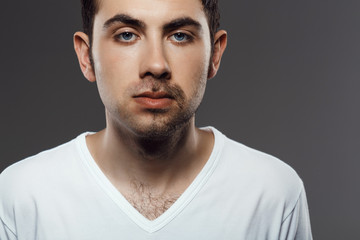 Portrait of young man after shaving over grey background.