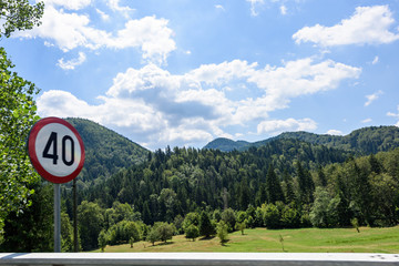 Photo of road sign and green forest in brasov mountains in the morning, Romania.