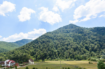 Photo of a village and green forest in brasov mountains in the morning, Romania.