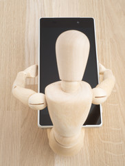 Wood figure holding cell phone