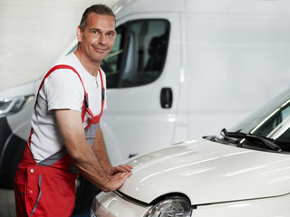 Car mechanic close engine bonnet after service