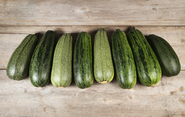 Fresh whole zucchini lying on a wooden table