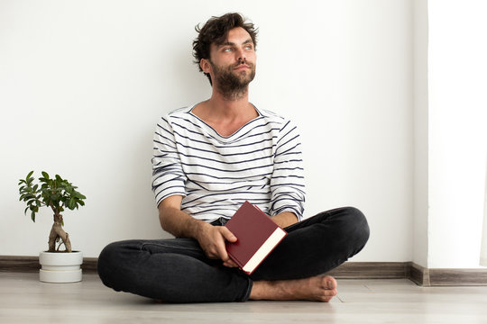man reading a book and standing on the floor - Powered by Adobe