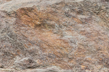 Stone background, rock wall backdrop with rough texture. Abstract, grungy and textured surface of stone material. Nature detail of rocks.
