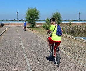 young brothers ride near the lagoon of Venice