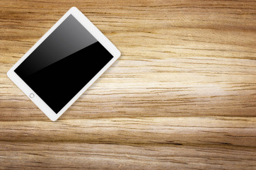 Digital tablet on wooden background.