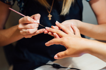 Obraz na płótnie Canvas Woman in salon receiving manicure