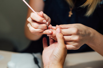Woman in salon receiving manicure