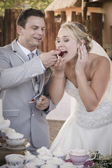 Groom stuffing brides face with cake.