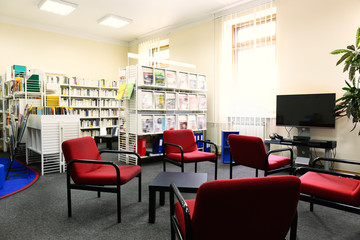 Modern library interior with red chairs