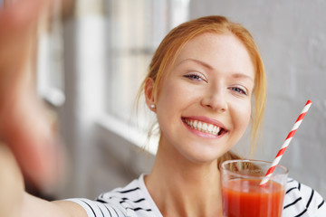 lachende frau trinkt tomatensaft