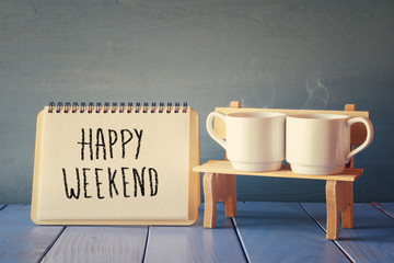 coffee cups next to notebook with phrase "happy weekend"