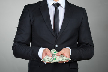 Unrecognizable businessman shows dollar banknote