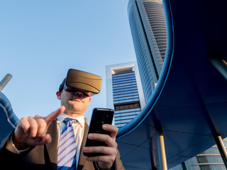 Businessman using virtual reality glasses with a mobile phone in