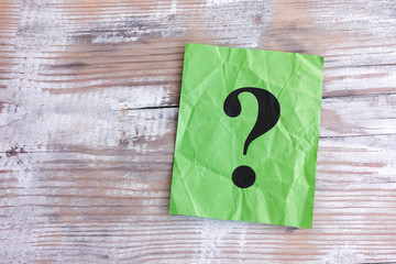 Green paper note with question mark