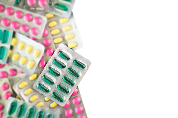 Green oil capsules foil on blurred colorful pills background