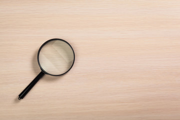 magnifying glass on the wooden background