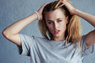 Fototapeta premium Female model posing in the studio for the cover of the magazine. The girl is very beautiful. The blonde with blue eyes. Street fashion.