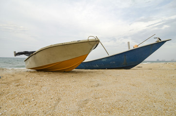 fisherman boat stranded on the sandy beach and cloudy sky.color toning applied.color toning applied