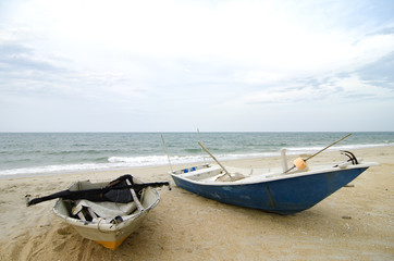 Naklejka premium closed up fisherman boat stranded on the sandy beach and cloudy sky.color toning applied.color toning applied
