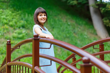 Beautiful young woman standing on the bridge