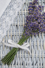Obraz premium Lavender bouquet and white lace handmade fabric on wicker background