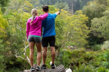 Athletic couple pointing at nature