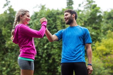 Athletic couple holding hands in forest