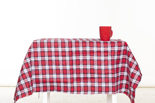 Picture of checkered table with cup on it