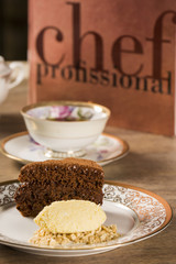 A slice of rich chocolate cake with ice cream and coffee
