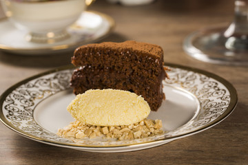 A slice of rich chocolate cake with ice cream and coffee