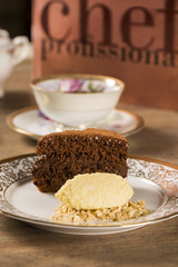 A slice of rich chocolate cake with ice cream and coffee