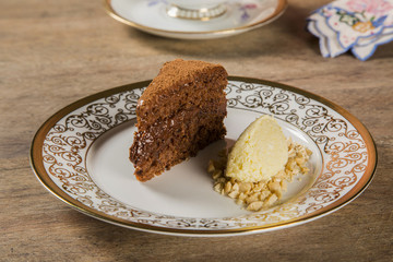 A slice of rich chocolate cake with ice cream and coffee