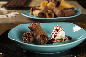 Cannoli with ice cream, chocolate and almonds