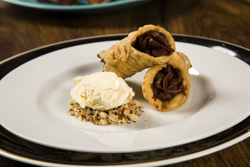Cannoli with ice cream, chocolate and almonds
