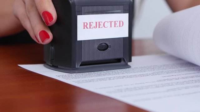 Girl refuses the terms of the contract and puts the appropriate stamp, close up