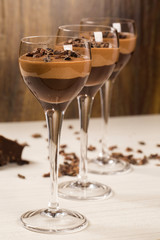 Chocolate mousse in a glasses on a wooden background