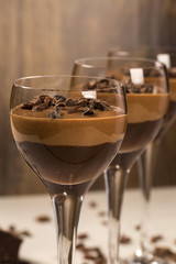 Chocolate mousse in a glasses on a wooden background