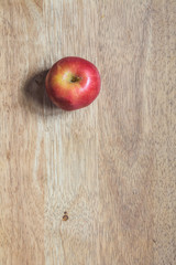 Red apple on a brown bright wooded table