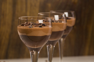 Chocolate mousse in a glasses on a wooden background