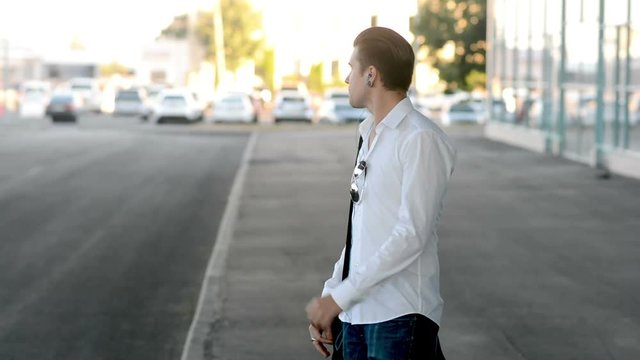 Man Walks And Listen Music From Headphones Near Business Centre, Shaking Head